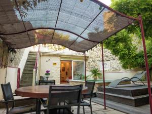 eine Terrasse mit einem Tisch, Stühlen und einem Sonnenschirm in der Unterkunft Attractive holiday home with swimming pool in Montagnac