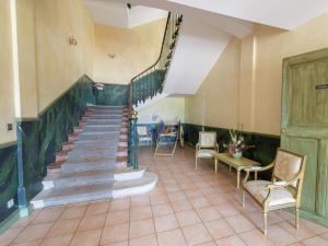 a staircase in a room with chairs and a table at Historical castle in Montbrun les Bains with pool in Montbrun-les-Bains