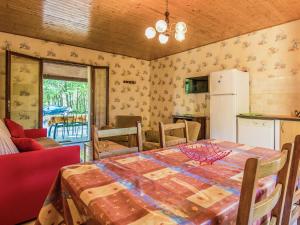 a kitchen and dining room with a table and a refrigerator at Holiday home with swimming pool in Salignac