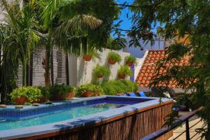 a swimming pool with plants on a fence at Casa de Isabella, a Kali Hotel in Santa Marta