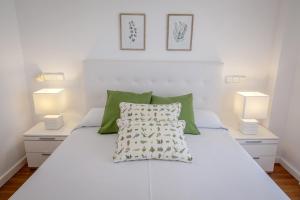 1 dormitorio con 1 cama blanca y 2 lámparas en AG GALEON, en Playa de Gandía