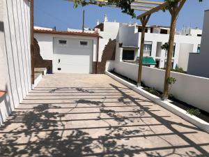 a driveway leading to a garage with white buildings at La Casita de la Parra, El Hierro in Tamaduste