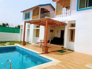 a house with a deck and a swimming pool at Bleu & Blanc in Pondicherry
