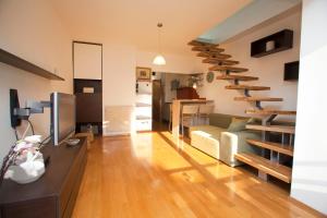 a living room with a couch and stairs in a room at Argola Kraljevica apartment in Kraljevica