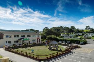 a park in front of a building with a playground at Newquay Bay Resort, Porth in Newquay