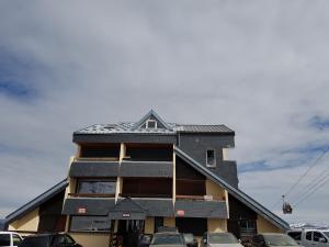 a house with a pitched roof with cars parked in front at studio saint lary soulan in Saint-Lary-Soulan