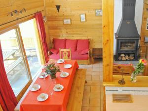 sala de estar con mesa roja y chimenea en Modern chalet just 350 m from the ski lifts en Peisey-Nancroix