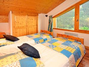 two twin beds in a room with a window at Luxurious Chalet in Champagny en Vanoise near Ski Area in Champagny-en-Vanoise