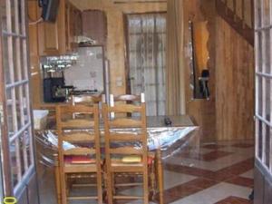 a kitchen with a table with chairs and a refrigerator at Cozy Cottage in Vaires sur Marne with Garden in Chelles