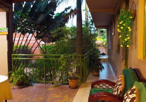 a balcony with plants and a green railing at Comfort Hotel Entebbe in Lyamutundwe