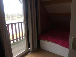 Dormitorio pequeño con puerta a un balcón en Thuiskomen, genieten aan het water, en Maaseik