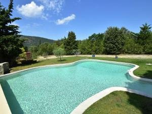 a swimming pool with blue water in a yard at Private infinity pool, beautiful view of Mont Ventoux, a dream spot! in Malaucène