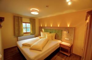 a bedroom with a large white bed and a window at Dienbergerhof 5 Sterne Ferienwohnungen in Untergriesbach +12 photos