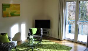 a living room with two chairs and a television at Hochwertiges Apartment im Grünen, zentral gelegen, ruhig, Balkon in Hannover