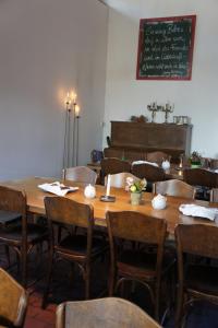 a dining room with a table and chairs and a chalkboard at Naturata Hotel in Überlingen