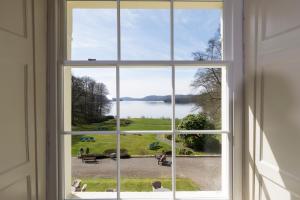 an open window with a view of a lake at Storrs Hall Hotel in Bowness-on-Windermere