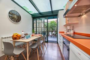 a kitchen with a table with chairs and a clock on the wall at Casa Entera A Ferradura in Melide