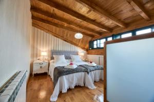 sypialnia z 2 łóżkami w pokoju z drewnianym sufitem w obiekcie Casa Entera A Ferradura w mieście Melide