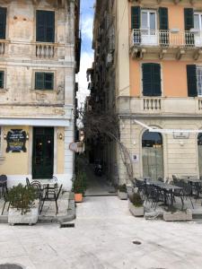 an alley with tables and chairs in front of buildings at Corfu Old Town Alexandra's Home in Corfu Town