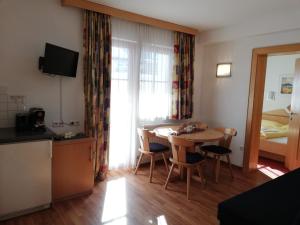 ein kleines Zimmer mit einem Tisch, einer Küche und einem Zimmer in der Unterkunft Apart Alba in Ischgl