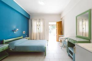 Dormitorio azul con cama y espejo en Panorama Apartments updated with infinity pool, en Agios Nikolaos