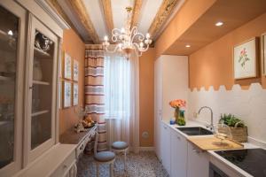 eine Küche mit orangefarbenen Wänden und einem Kronleuchter in der Unterkunft Venezia Ca' Drì Apartment in Venedig