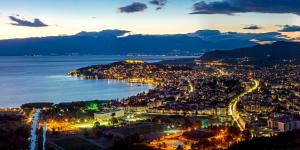 uma vista de uma cidade à noite com a água em Protuger em Ohrid