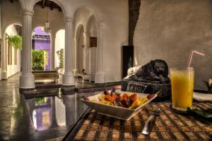 a bowl of fruit on a table with a drink at Casa de Leda, a Kali Hotel in Santa Marta
