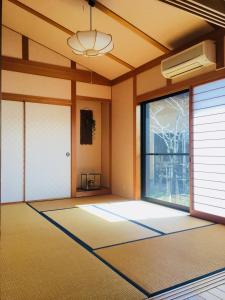 une chambre vide avec une porte et une fenêtre dans l'établissement Shimanto River House Yuube-Tei, à Shimanto