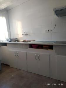 a kitchen with white cabinets and a counter top at Hispanoconcucense in Teruel +12 photos