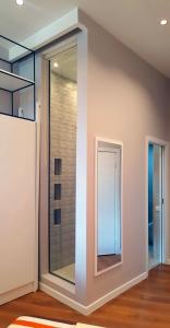 a glass door in a room with a mirror at Europa Apartment in Tirana