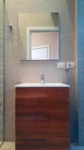 a bathroom with a sink and a mirror at Europa Apartment in Tirana