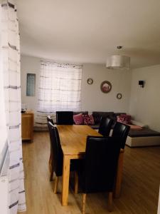 comedor con mesa, sillas y sofá en Ferienwohnung Koller, en Wernberg