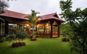 
a large green and white house with trees at Fun Retreat Resort, Hotel and Ayurveda Spa in Arusha
