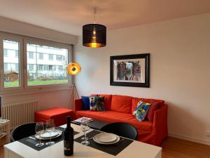 uma sala de estar com um sofá vermelho e uma mesa em Geneva Cosy em Genebra