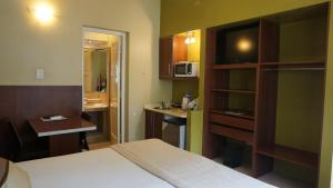 une chambre d'hôtel avec un lit et une petite cuisine dans l'établissement Casacerro, à Salta