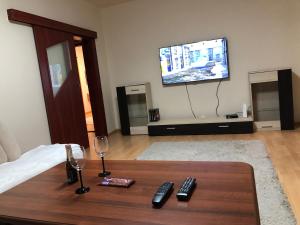 uma sala de estar com uma mesa com copos de vinho e uma televisão em Apartment Sever Hroncova em Košice