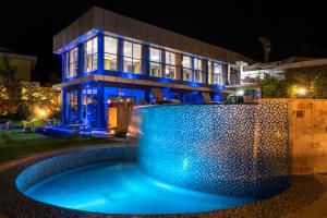 a house with a swimming pool at night at Fun Retreat Resort, Hotel and Ayurveda Spa in Arusha