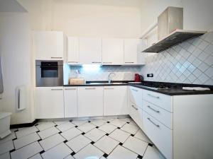 a kitchen with white cabinets and a tile floor at DIMORA DI FAMAGOSTA CENTRO - GENOVABNB it in Genoa
