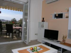 Televízia a/alebo spoločenská miestnosť v ubytovaní Apartments Biljana for relaxing holidays in Baska