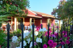 a fence in front of a house with flowers at Issos Apartments in Corfu