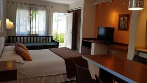 a bedroom with a bed and a desk and a television at Casacerro in Salta