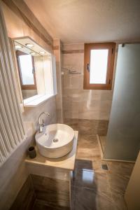 ein Bad mit einem Waschbecken und einem Spiegel in der Unterkunft Bay View Apartments in Sitia