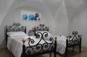 two beds in a bedroom with white walls at Casa Vacanze: Le Tre Stelle in Nardò