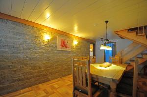 een eetkamer met een houten tafel en een bakstenen muur bij Ferienhaus Hinterzarten in Hinterzarten