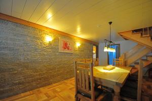 a dining room with a wooden table and a brick wall at Ferienhaus Hinterzarten in Hinterzarten