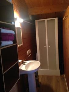 a bathroom with a sink and a cabinet with towels at CHALET GOYAVE in Épaignes