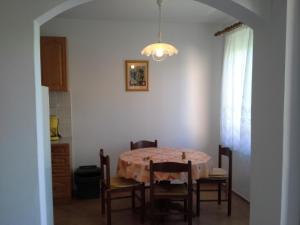 comedor con mesa y algunas sillas en Apartman Pavla, en Baška