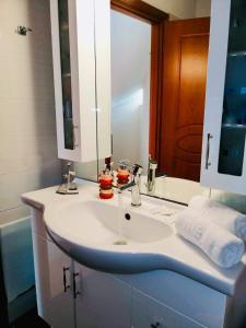 ein Badezimmer mit einem weißen Waschbecken und einem Spiegel in der Unterkunft House of Light in Sitia