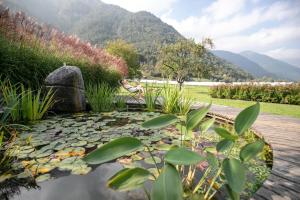 レードロにあるDa Elda Natural Retreatの池の横のベンチに座る者